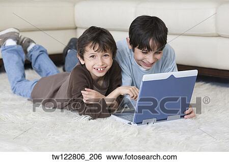 Hispanic brothers looking at laptop View Large Photo Image Stock Photograph - Hispanic brothers looking at laptop. Fotosearch