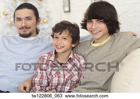 Hispanic brothers sitting on sofa View Large Photo Image Stock Image - Hispanic brothers sitting on sofa. Fotosearch
