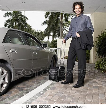 Hispanic businessman holding suitcase next to car View Large Photo Image Stock Image - Hispanic businessman holding suitcase next to car. Fotosearch
