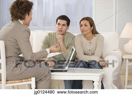 Hispanic businesswoman talking to couple in home View Large Photo Image Stock Image - Hispanic businesswoman talking to couple in home. Fotosearch