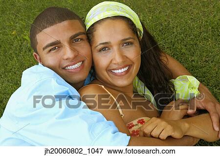 Hispanic couple hugging in grass View Large Photo Image Stock Photo - Hispanic couple hugging in grass. Fotosearch