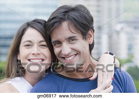 Stock Photo - Hispanic couple hugging outdoors. Fotosearch