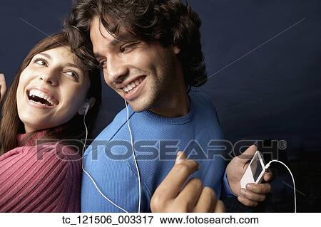 Stock Photo - Hispanic couple listening to same mp3 player. Fotosearch