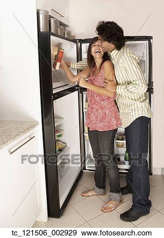 Hispanic couple looking in refrigerator View Large Photo Image Stock Photo - Hispanic couple looking in refrigerator. Fotosearch