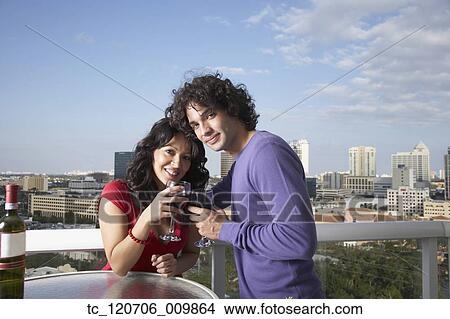 Hispanic couple toasting on balcony View Large Photo Image Picture - Hispanic couple toasting on balcony. Fotosearch