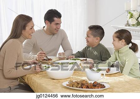 Hispanic family eating at dinner table View Large Photo Image Stock Photograph - Hispanic family eating at dinner table. Fotosearch