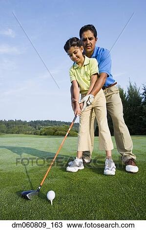 Hispanic father helping daughter play golf View Large Photo Image Stock Image - Hispanic father helping daughter play golf. Fotosearch