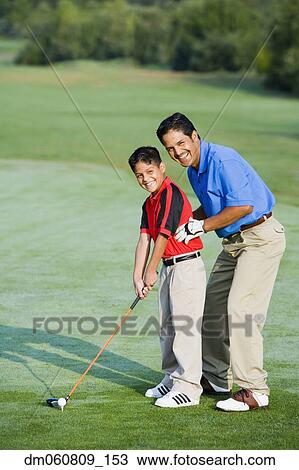 Stock Image - Hispanic father helping son play golf. Fotosearch