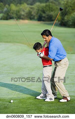 Hispanic father helping son play golf View Large Photo Image Stock Photo - Hispanic father helping son play golf. Fotosearch