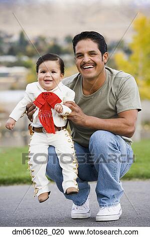 Hispanic father holding baby in costume View Large Photo Image Stock Image - Hispanic father holding baby in costume. Fotosearch