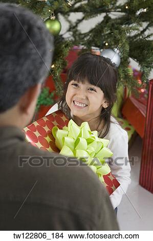 Hispanic girl giving Christmas gift to father View Large Photo Image Picture - Hispanic girl giving Christmas gift to father. Fotosearch