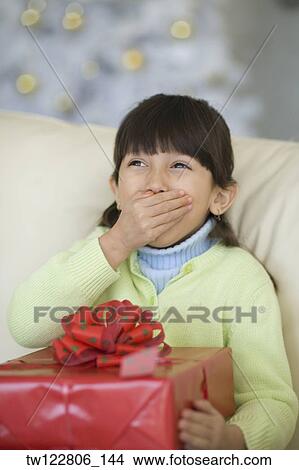 Hispanic girl holding Christmas gift View Large Photo Image Picture - Hispanic girl holding Christmas gift. Fotosearch