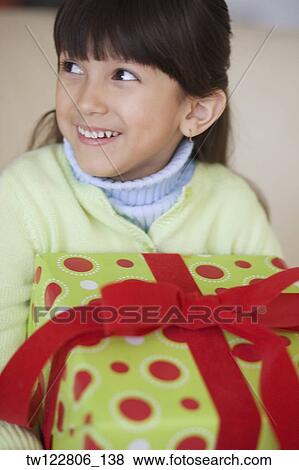 Stock Photo - Hispanic girl holding gift. Fotosearch