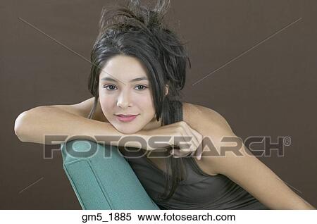 Stock Photography - Hispanic girl resting chin on arm. Fotosearch