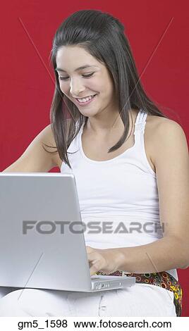 Stock Photo - Hispanic girl typing on laptop. Fotosearch