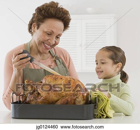 Hispanic grandmother and granddaughter basting roast turkey View Large Photo Image Stock Image - Hispanic grandmother and granddaughter basting roast turkey. Fotosearch