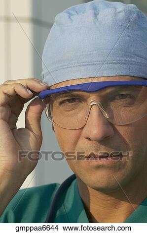 Picture - Hispanic male doctor wearing surgical glasses. Fotosearch