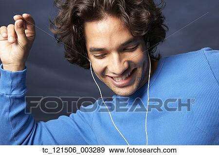 Stock Photo - Hispanic man dancing to mp3 player. Fotosearch