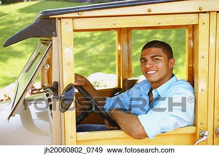 Hispanic man driving old fashioned car View Large Photo Image Stock Photo - Hispanic man driving old fashioned car. Fotosearch