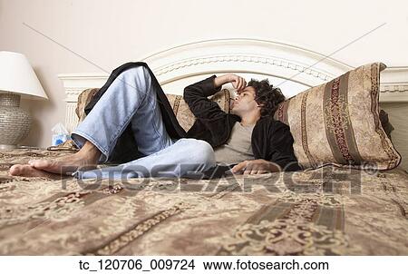 Hispanic man laying on bed View Large Photo Image Picture - Hispanic man laying on bed. Fotosearch