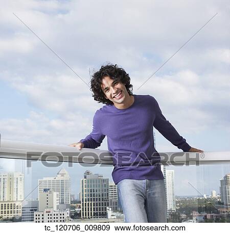Hispanic man leaning against balcony railing View Large Photo Image Stock Photo - Hispanic man leaning against balcony railing. Fotosearch