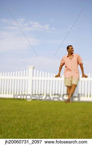 Hispanic man leaning on fence View Large Photo Image Stock Photo - Hispanic man leaning on fence. Fotosearch