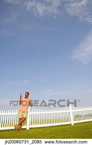Hispanic man leaning on fence View Large Photo Image Stock Photography - Hispanic man leaning on fence. Fotosearch