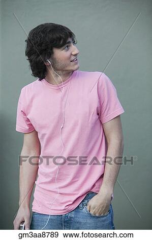 Stock Photo - Hispanic man listening to mp3 player. Fotosearch