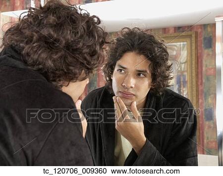 Hispanic man looking in bathroom mirror View Large Photo Image Stock Image - Hispanic man looking in bathroom mirror. Fotosearch