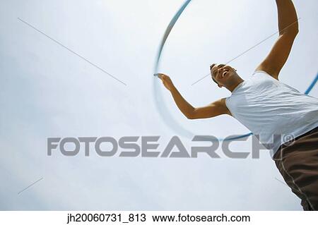 Hispanic man playing with hula hoop View Large Photo Image Stock Image - Hispanic man playing with hula hoop. Fotosearch