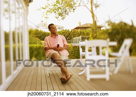 Hispanic man sitting on patio View Large Photo Image Picture - Hispanic man sitting on patio. Fotosearch