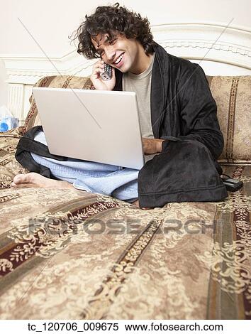 Hispanic man talking on telephone in bed View Large Photo Image Stock Photography - Hispanic man talking on telephone in bed. Fotosearch