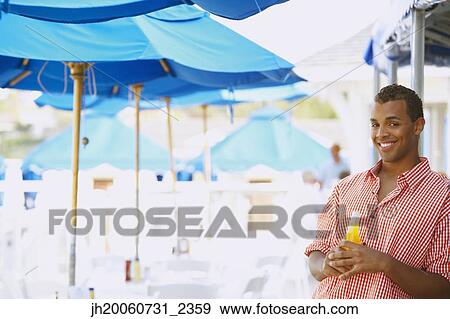 Hispanic man with drink at beach View Large Photo Image Stock Photo - Hispanic man with drink at beach. Fotosearch