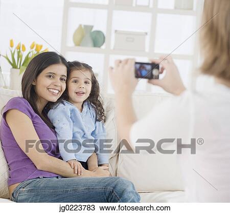 Stock Image - Hispanic mother and daughter having photograph taken. Fotosearch