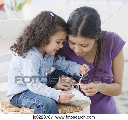 Hispanic mother helping daughter tie shoe View Large Photo Image Stock Photo - Hispanic mother helping daughter tie shoe. Fotosearch