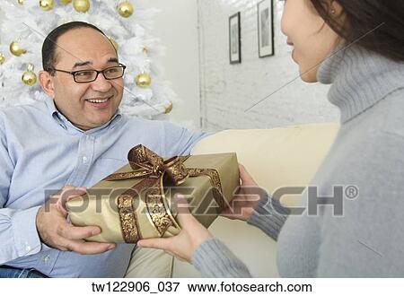 Hispanic woman giving gift to man View Large Photo Image Stock Photo - Hispanic woman giving gift to man. Fotosearch