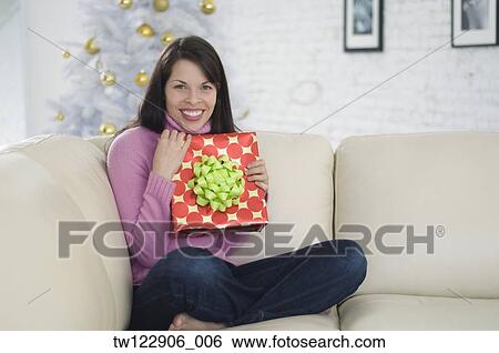 Hispanic woman holding Christmas gift View Large Photo Image Stock Photograph - Hispanic woman holding Christmas gift. Fotosearch