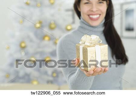 Hispanic woman holding Christmas gift View Large Photo Image Stock Photography - Hispanic woman holding Christmas gift. Fotosearch