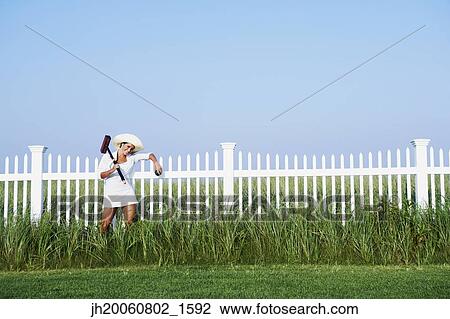 Hispanic woman holding croquet mallet View Large Photo Image Stock Image - Hispanic woman holding croquet mallet. Fotosearch