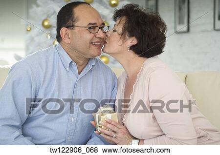 Hispanic woman kissing husband on Christmas View Large Photo Image Stock Photo - Hispanic woman kissing husband on Christmas. Fotosearch