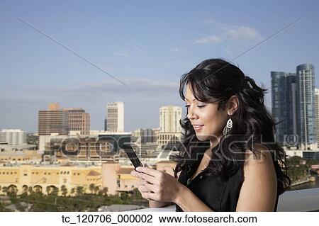 Hispanic woman looking at cell phone View Large Photo Image Stock Image - Hispanic woman looking at cell phone. Fotosearch