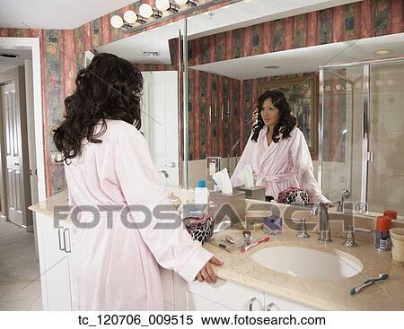 Hispanic woman looking in bathroom mirror View Large Photo Image Stock Photography - Hispanic woman looking in bathroom mirror. Fotosearch