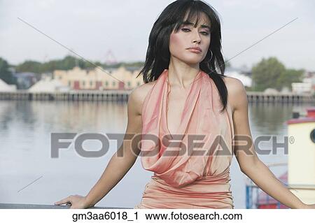 Stock Image - Hispanic woman next to urban river. Fotosearch