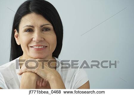 Stock Photo - Hispanic woman resting chin on hands. Fotosearch