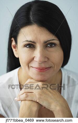 Stock Photo - Hispanic woman resting chin on hands. Fotosearch