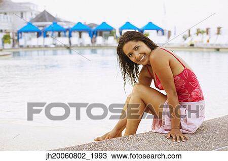 Hispanic woman sitting next to swimming pool View Large Photo Image Stock Image - Hispanic woman sitting next to swimming pool. Fotosearch