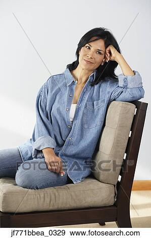 Stock Photo - Hispanic woman sitting on chair. Fotosearch