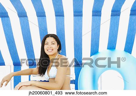Hispanic woman sitting under beach sun shade View Large Photo Image Stock Image - Hispanic woman sitting under beach sun shade. Fotosearch