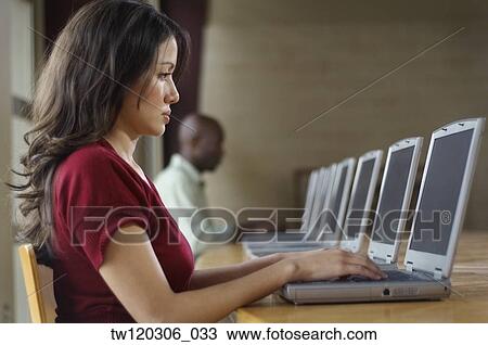 Hispanic woman using laptop at computer lab View Large Photo Image Stock Image - Hispanic woman using laptop at computer lab. Fotosearch