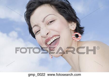 Stock Image - Hispanic woman wearing funky earrings. Fotosearch